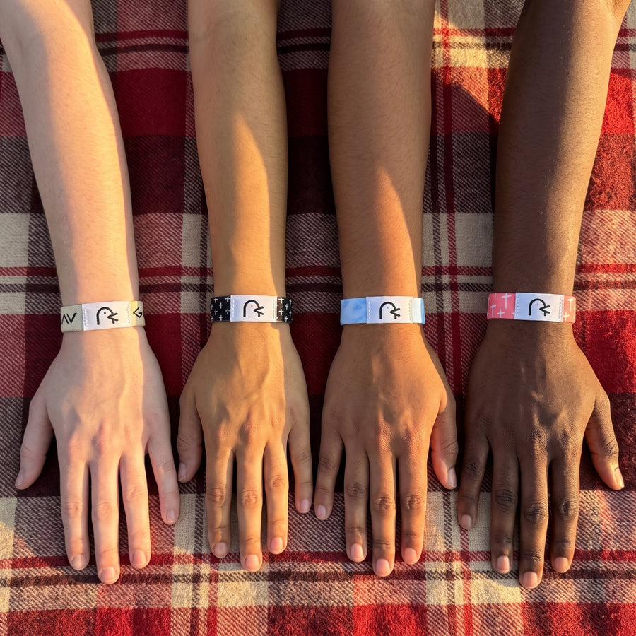 Four friends' wrists side by side, each wearing a Daily Verse band