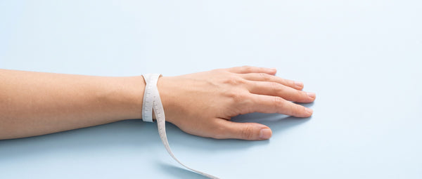 A tape wrapped once around a wrist, just below the wrist bone