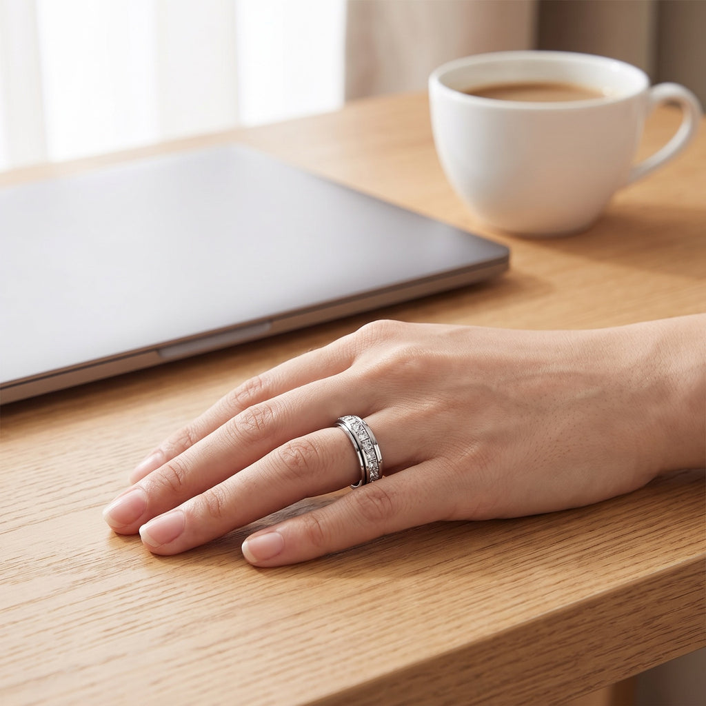 Calm Spinner Ring – worn on a hand resting on a desk beside a laptop and coffee