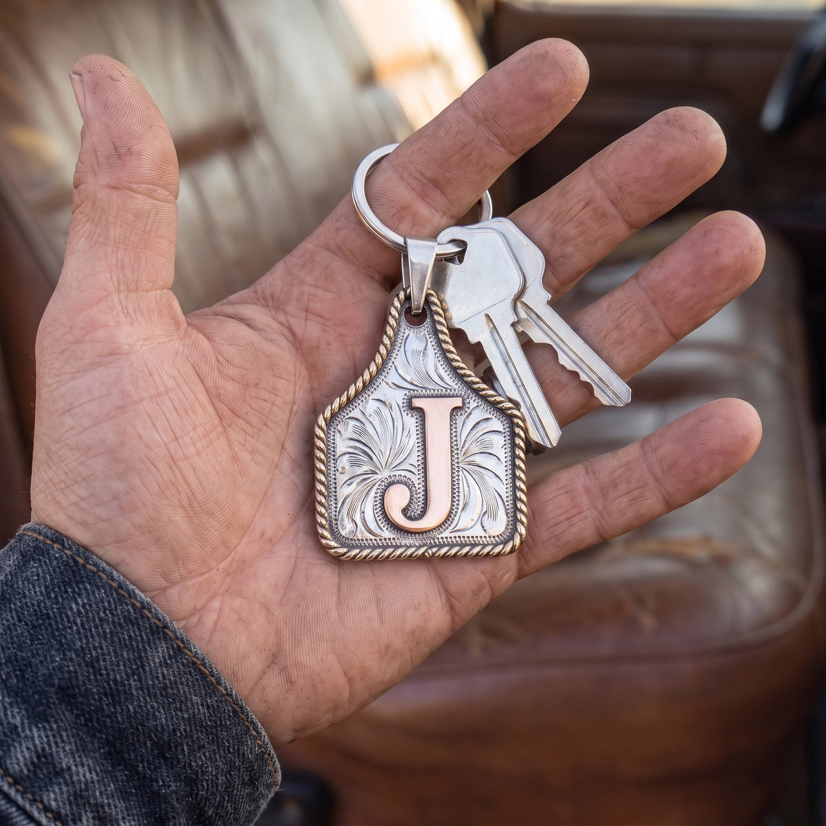 Cow Tag Initial Necklace & Keychain – letter J cow tag as a keychain with truck keys, held in an open hand